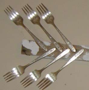 Repurposed antique dessert forks suggestive of arrow feathers